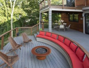 Gemütliche Holzterrasse mit Feuerstelle, Lounge und Sitzgelegenheiten im Garten.