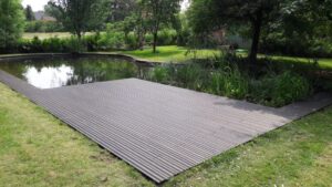 Moderne Holzterrasse am Teich mit Naturumgebung im Garten.