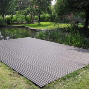 Moderne Holzterrasse am Teich mit Naturumgebung im Garten.